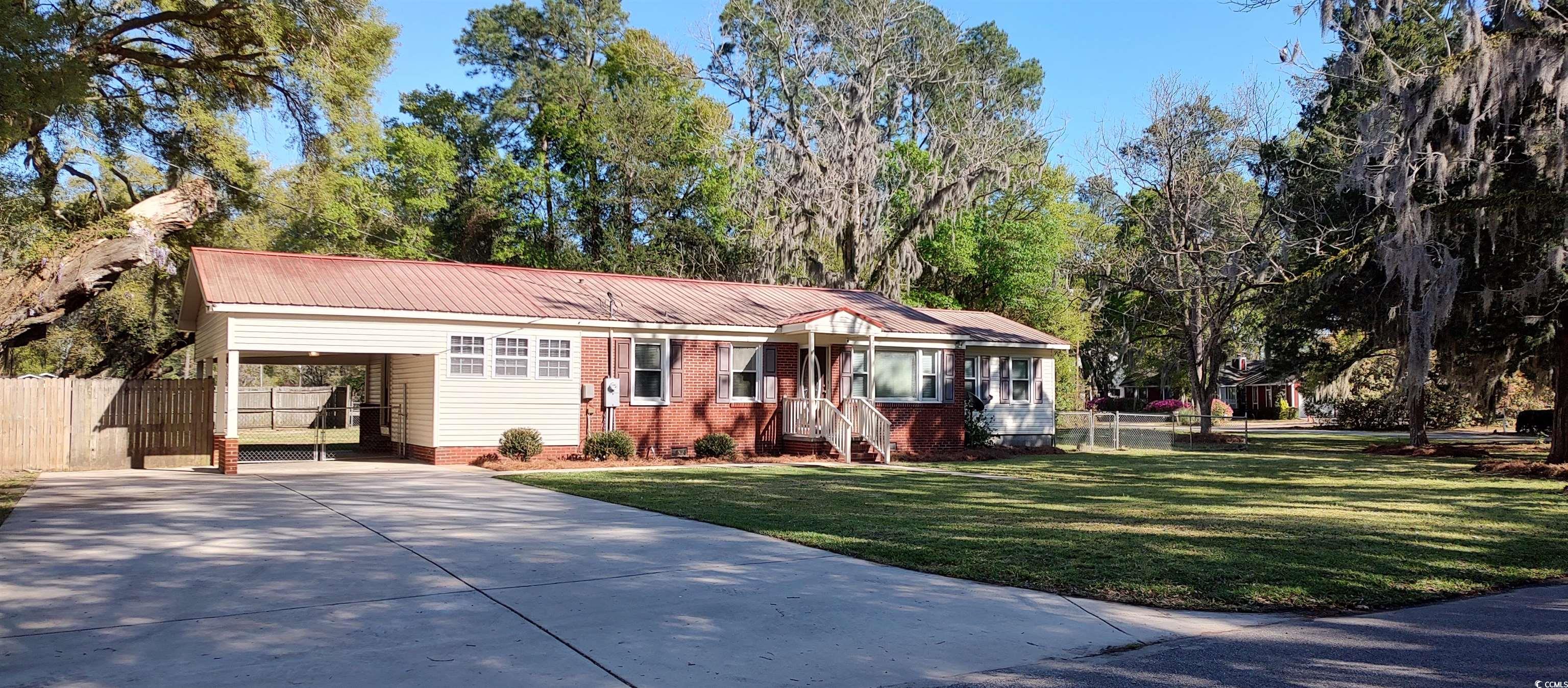 a classic home in the midst of a yard with large cedars, producing pecan trees, a historic 300 year old live oak azaleas and wisteria; a beautiful south carolina photo in your own yard.  in the waterford estates section of georgetown, this 3 bedroom, 2 bath brick home sits on almost an acre of  land.  home has been newly remodeled with paint, new carpet, and has original hardwood floors  side yard contains an enclosed 21x21 shop with 60 amp power, cable and a 12x21 lean to off the back. the additional 25x21 carolina carport is perfect for your boat & camper storage as the black river surrounds the community and several landings are nearby. back yard is fenced and has a gate opening to the back street . home has never flooded and there is no hoa. historic georgetown with the harborwalk, shopping and fine dining is only a few miles away and the beaches of pawleys island 18 miles.