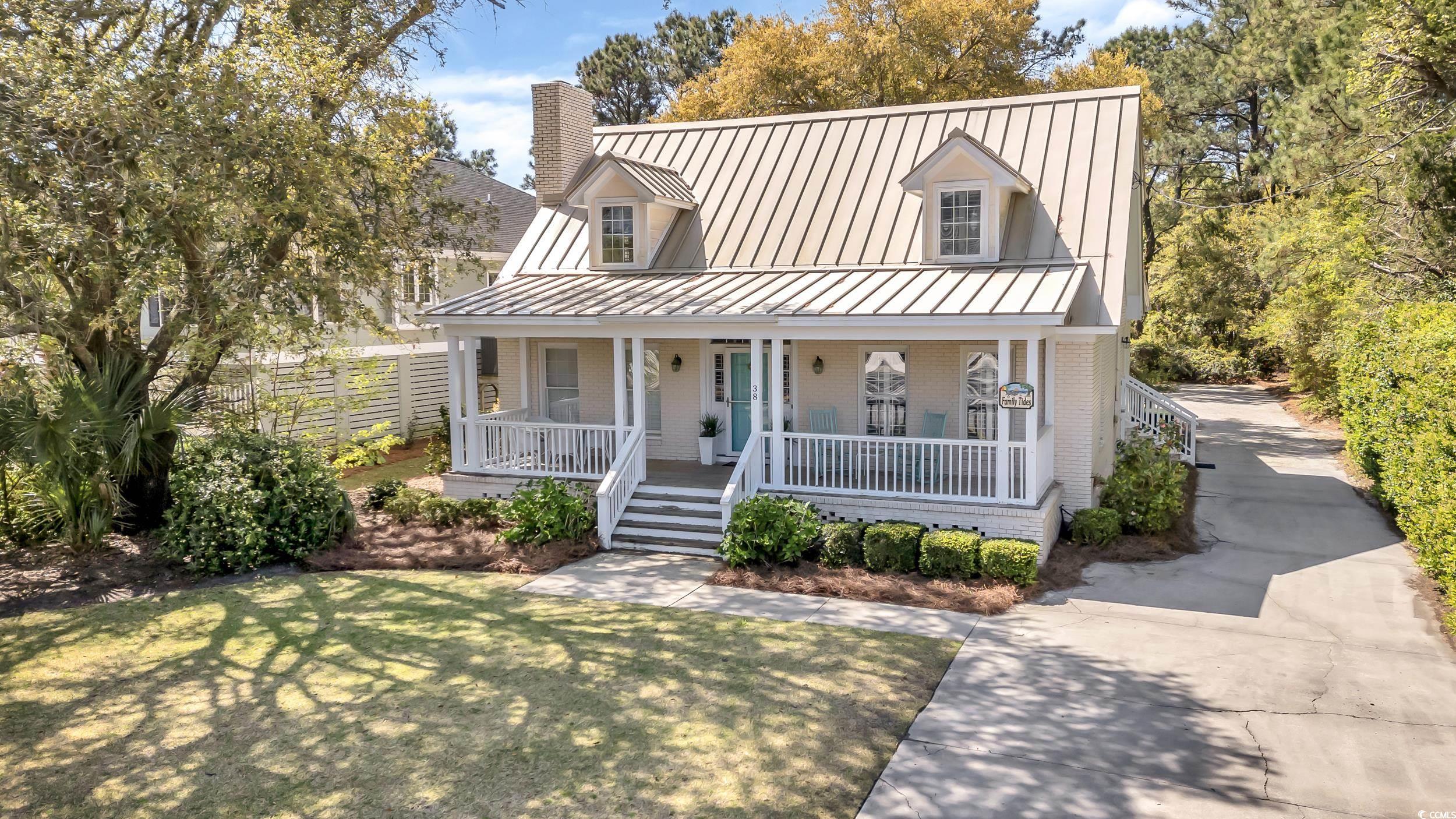 introducing coastal living at its best in this charming beach-style cottage is located in the picturesque community of north litchfield beach in pawleys island, sc.   the exterior of this delightful home welcomes you with a wide front porch and low country style metal roof, situated on a beautiful homesite nestled among mature foilage and landscaping.  it boasts four bedrooms and three and a half bathrooms, providing ample space for family and friends to enjoy a beach getaway.  the primary bedroom with it's own en-suite bathroom is located on the main level.  the living room features a wood burning masonry fireplace and a wide array of seating.  the spacious kitchen is equipped with modern appliances and plenty of counter space and seating.  it is the perfect place to prepare meals and create lasting memories with loved ones.  off the kitchen, you will find a cozy and relaxing den that includes an additional wood burning masonry fireplace.  the beautiful heart of pine floors and pecky cypress ceiling is surrounded by large windows and sliding doors leading out to the back deck.         in addition to the main house, there is a detached garage on the property.  this versatile space not only provides parking, but also offers the potential for a gameroom, or future pool house.  the possibilities are endless!  the best highlight of this home is it's proximity to the beach.  just a short walk to the warm sand and soothing sounds of the ocean. whether you're looking to relax by the water or take a refreshing swim, the beach is easily accessible from this charming home.  pawleys island is located south of the murrells inlet and myrtle beach area.  its approximately 80 miles south of historic charleston, allowing for a wonderful day trip.