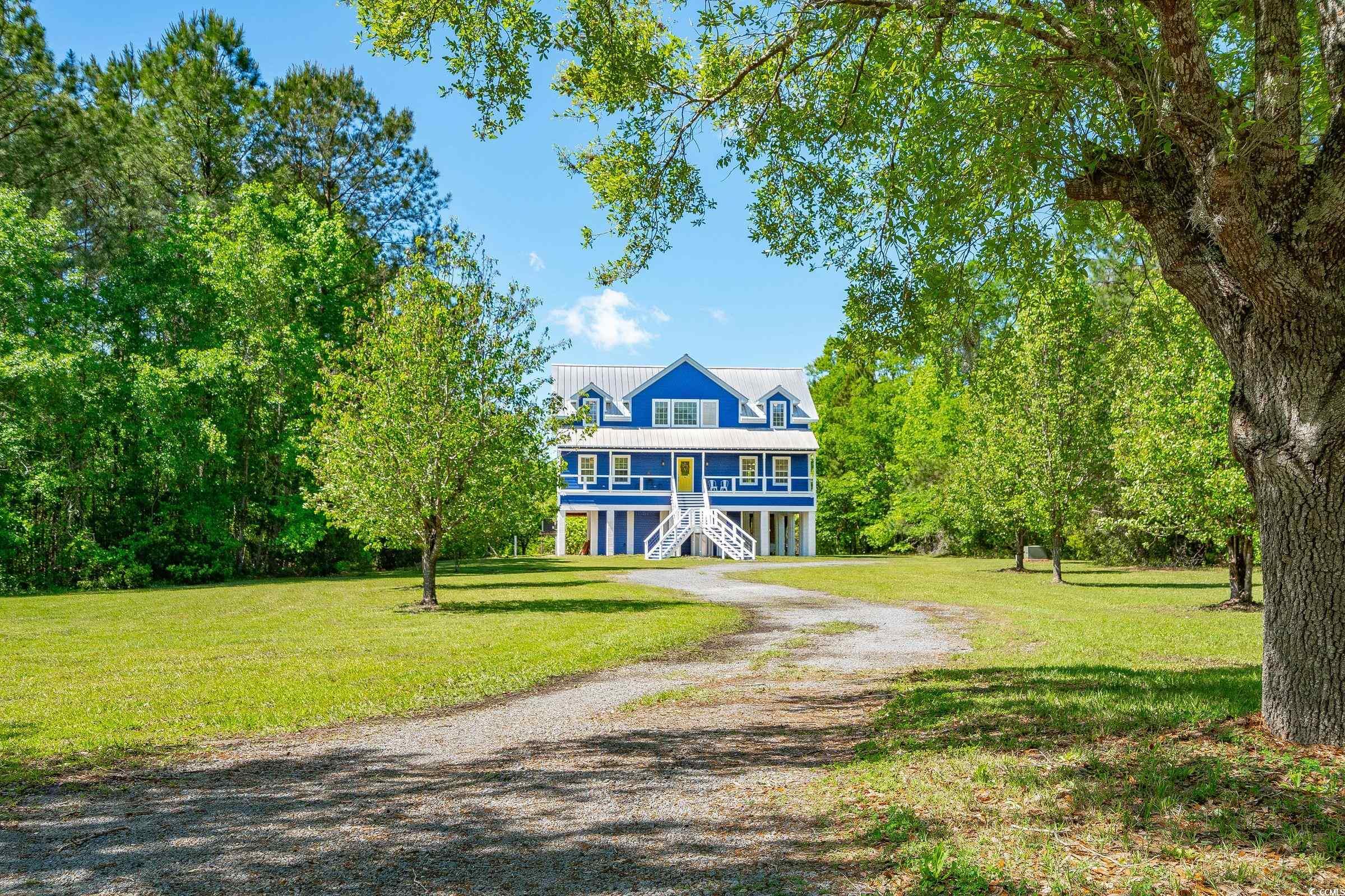 welcome to this 'riverhouse contemporary' retreat resting on 2.6 acres with a deep water dock on the north santee river. charming and unique home featuring painted wood floors, cathedral ceilings, and designer lighting creating a coastal vibe. expansive back screened porch overlooks the wetlands and river beyond. recently updated kitchen featuring custom cabinets, quartz countertops, large butcher block center island, stainless steel appliances, and a farmhouse sink. five bedrooms in the main house with the primary suite on 1st floor, and an additional bedroom and half bath underneath, along with a hot 'lap' tub/spa, outdoor shower, and extra storage space. 2 brand new hvacs just installed. wildlife galore and great river access with good catfish fishing. the full front porch and metal roof compliment the exterior of this well thought-out home. private and secluded, yet only a short drive into downtown georgetown, and 30 minutes from mt. pleasant.