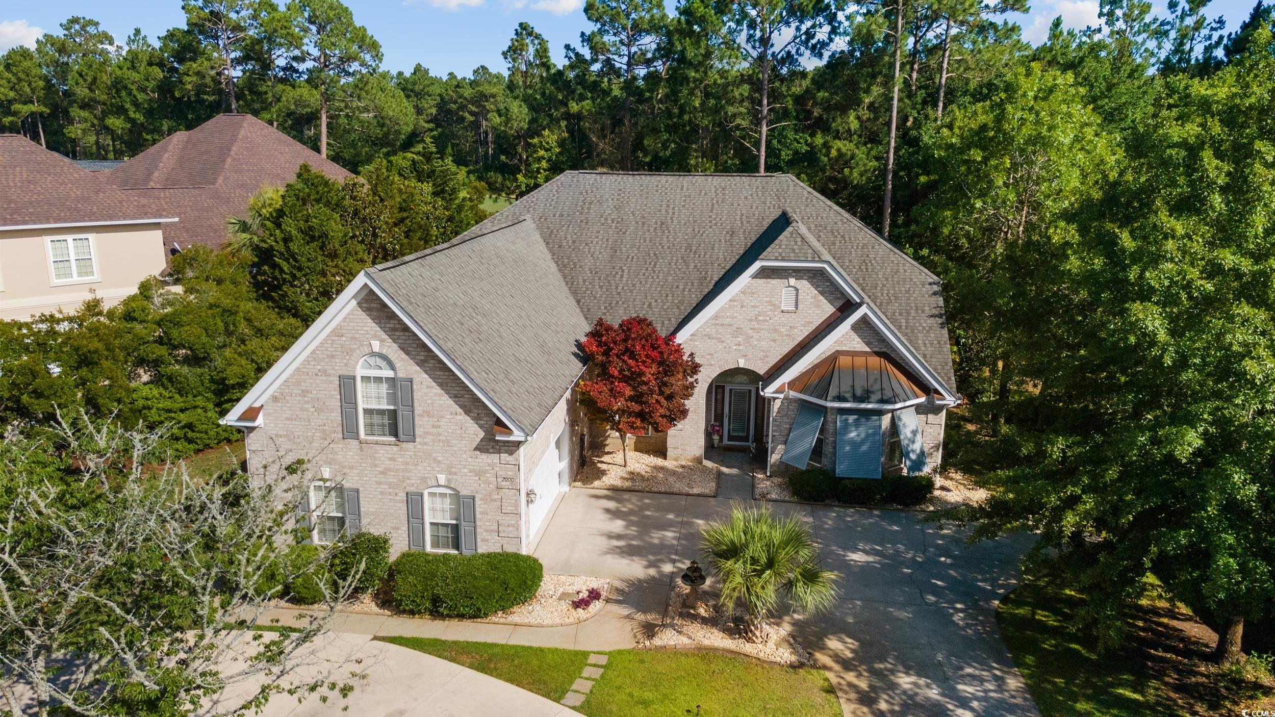 Approaching the home you are greeted with professional landscaping with an added roundabout driveway that can hold 6 cars plus the attached garage. Moving into the arched doorway, you will find beautiful Bahama Shudders to keep the home cool. When you enter the home, you are immediately drawn to vaulted ceilings that cover an amazing living space. A formal dining room, updated kitchen with two refrigerators, double oven, granite countertops, dual sinks with extra counter space.,all new stainless steel appliances, also features a water filtration system.   A built-in work area that currently is used as a small office. This open floor plan looks over a huge living room that has amazing windows and are covered with professional Plantation Shudders.  A formal sitting room with a fireplace that is just off the kitchen could be used for another eating area. Two master suites downstairs with a third bedroom with the upstairs having its own 2 bedrooms and bath. Outside you will find a screened Lanai, medically approved hot tub, and a firepit,hold house Generac Generator, new Trane HVAC, All this overlooking the world-famous Legends Golf Course. The neighborhood features an amazing amenity center, three golf courses, driving range, clubhouse, all within a gated community. This one is a must see!!!