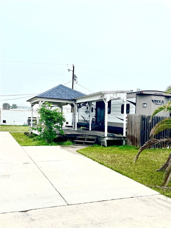 Fantastic location of this large lot zoned for short term rentals in the heart of Port A! Nestled on a quiet street with no through streets and literally just minutes to the beach, dining, shopping and entertainment. Ideal as a fisherman's getaway! There is a 2 bedroom, 2 bath "destination trailer" on a concrete pad with a large concrete driveway and parking for multiple vehicles. It is furnished plus 3 high definition TV's and an AC replaced in April 2023. Enjoy a cold beverage on the spacious, covered deck while the kids play in the yard with privacy fencing. The trailer is registered with the State and comprehensive insurance is in place. There is also a large storage container on the back of the lot ideal for beach gear, fishing equipment, outdoor furniture etc. when not in use. No deed restrictions and no HOA! Taxes in 2022 were $1,909. Great opportunity to build your island home w/ plenty of room for a pool & building memories. Rental income will offset the expense of ownership!