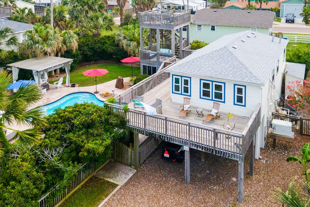Ask any Port Aransas local where they want to live and THIS IS THE NEIGHBORHOOD! 706 Tarrant Avenue is located on a huge lot just around the corner from the beach offering all the amenities you need for island living at its finest! The outdoor space is worthy of a resort with a gorgeous pool, flatwork, lush, mature landscaping, a lighted pergola with firepit, a screened in entertainment area and a sky-high observation tower. You will love the 360-degree views of the beach, the ship channel, and St. Joe's Island. Super cool house with vintage touches from as early as the 40s including long leaf pine flooring, beadboard walls, and mahogany countertops. Upstairs is living, kitchen, master suite, sitting area & powder room. Down is a 2/2 with large kitchenette/dining for your guests or use it as a pool house. Decks, porches & patios galore! Modern upgrades include new windows and doors, roof, generator, tankless water heater, water softener & more. Love it as is or upgrade it even more!