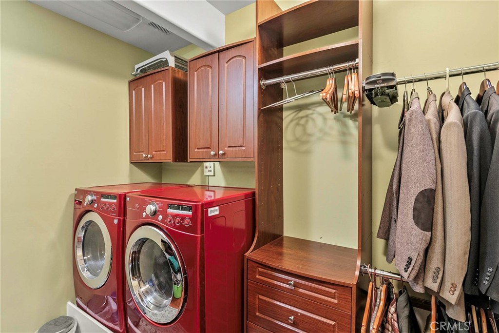 Level 1: Primary walk in closet with laundry area and custom closet organizer