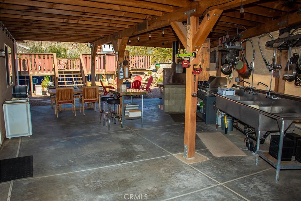 550 square foot Giant rear patio/outdoor kitchen includes:  Wood burning pizza oven with 4 foot inside diameter, Jenn-Air 4 burner stainless BBQ with infrared rotisserie, 3 compartment commercial sink with 2 pull down restaurant style faucet sprayers, 2 overhead pot racks.