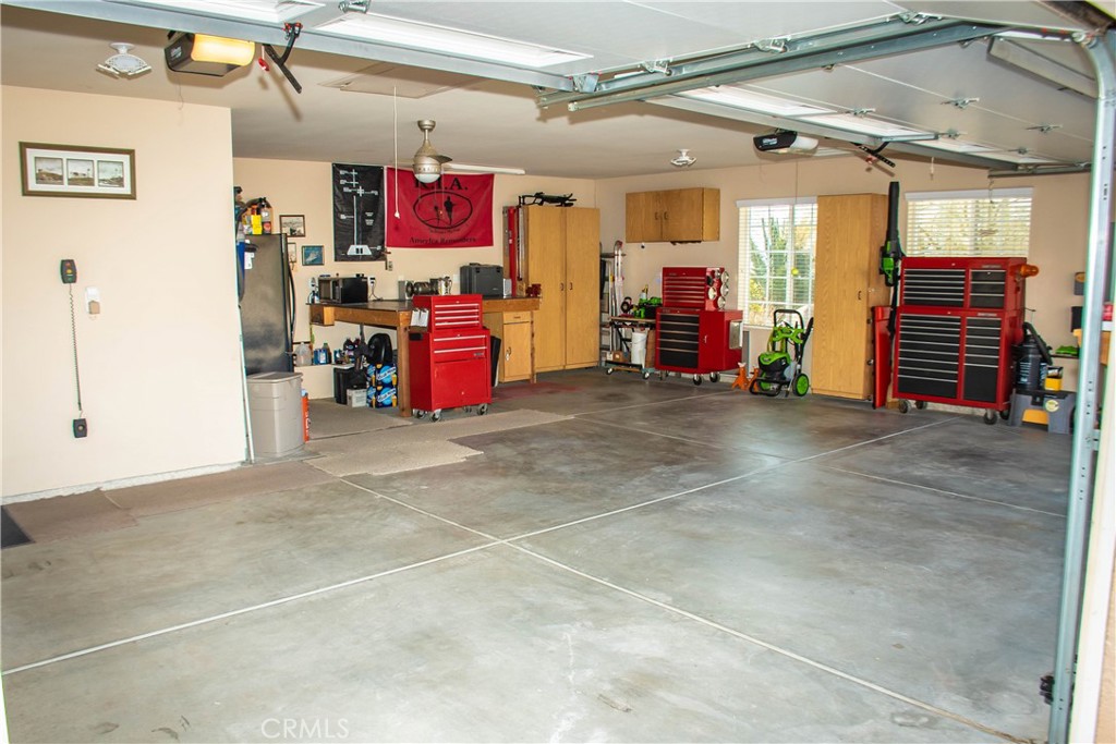 Finished garage with 2 openers, insulated garage doors, workshop with l-shape work bench including steel tops, built in cabinets and antique wash station.