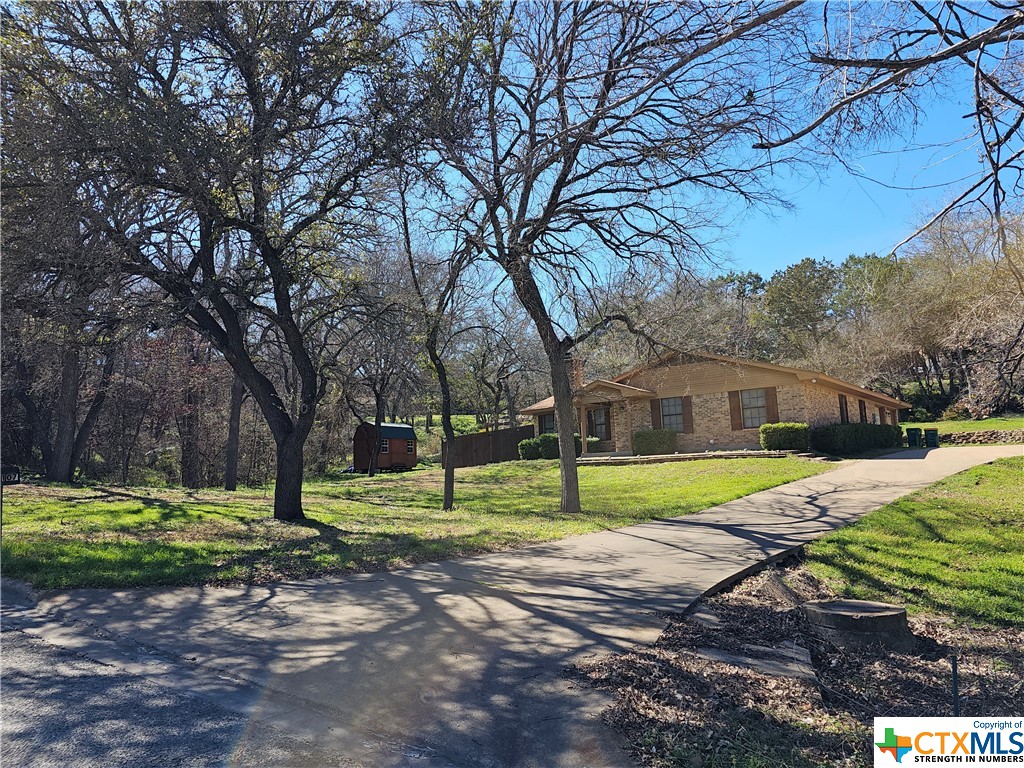 This charming, well-kept, 1374 Sq. Ft. Brick home sits on a large .491 acre lot on a cul-de-sac in Creek Cliff Estates. Entry way has a nice coat closet. The cozy living area has a wood-burning fireplace and is open to the kitchen and dining area. Kitchen has Granite counters with a Breakfast Bar. Electric Range, Microwave, Refrigerator and Dishwasher all convey. 
This home has a great floor plan with 3 Bedrooms with Walk-In Closets (Master has 2), 2 Full Baths with Granite counters and plenty of storage. The attached bed in Bedroom 2 is negotiable as well as the TV wall mounts. 
Outside there is a large front yard with mature trees and nice shrubs on the front and side. In the back there is a ~14'5'' x 8'10"  covered patio and a fenced area for the pets. From the patio, there is a nice view of the wooded hillside. There is also a ~ 12'3" x 8'3" storage building secured on concrete blocks for extra storage. 
This property is easily accessed from the Chicktown Road entrance of Creek Cliff Estates via Dodds Creek Dr.  
There is an optional HOA for use of the Community Pool for $250 per year.
Disclaimer: A part of the Middle Trinity Ground Water Conservation District. Sq. footage provided by the Coryell Co Appraisal Dist., NOT the Listing Broker /Agents. Measurements & taxes are approximate. Buyer should verify all information including utility availability.