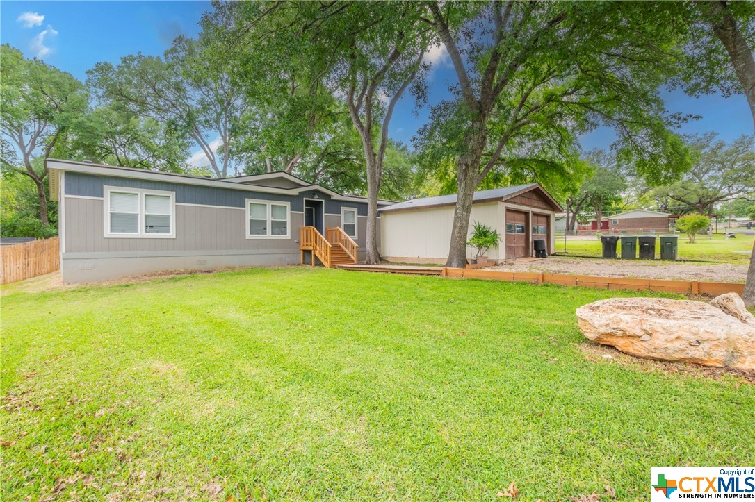 Hidden Gem near Lake Belton!  This 2021 Manufactured home features 3 bedrooms, 2 bathrooms, and a fun room (could be used for a 4th bedroom) and detached 2 car garage. Great kitchen with electric appliances, separate pantry, beautiful tile backsplash, and huge center island.  Open concept to dining and large living area with wood like laminate flooring throughout home except in bedro0ms (carpet).  Split floorplan featuring 2 nice sized secondary bedrooms PLUS a great fun room/office/4th bedroom/2nd living area.  Big lot with mature trees and new privacy fence in back yard.