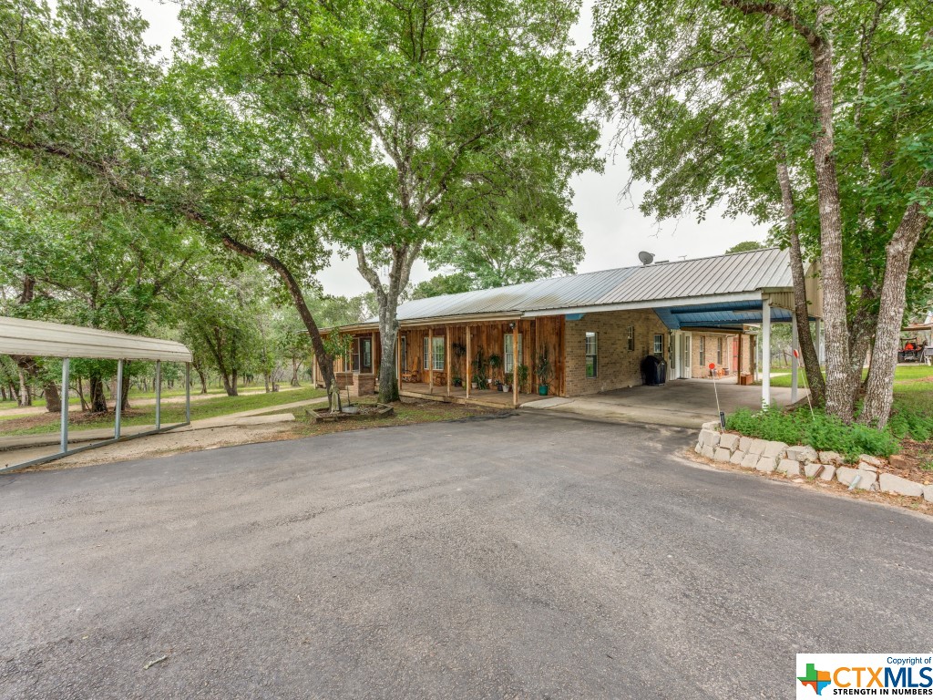With deer occasionally grazing nearby, you'll feel a sense of peace and connection with nature on this tranquil, 2.55-acre property. Built in 1996, the centerpiece of the acreage is a 2,340-square-foot brick home that exudes rustic charm as you enter the gate and come up the circle driveway. Further exploration of the property reveals that there is also an additional 600 square feet of attached storage in the back of the house and two carports, perfect for storing your vehicles and outdoor equipment. The property also boasts 1740 square feet of multi-use out-buildings, complete with multiple rooms that offer endless possibilities for hobbies and creative endeavors. And when it's time to unwind, the huge covered porch with an attached patio/plant room invites you to sit back and relax and watch the world go by. As you enter the house, you'll be impressed by the ambiance that permeates every corner of the living space, which includes three bedrooms and two full bathrooms. However, there's more – an attached apartment awaits, complete with a living room, bedroom, kitchenette, and bathroom. This additional living space brings the total to four bedrooms and three full bathrooms, making it perfect for guests or live-in family members who may need a bit of extra space and privacy. And with handicap accessible enhancements throughout, everyone can feel at home. Entertain guests in style in the dining room, featuring gorgeous floor-to-ceiling built-in cabinetry with glass doors, perfect for displaying your most treasured possessions. Both kitchens are equipped with double ovens, making meal preparation a breeze. And with a whole home filtration system in place, you can enjoy water straight from the tap. Outside, a sprinkler system surrounds the house, ensuring your lawn and plants are watered all year round. Plus, with a newer HVAC system, you can stay comfortable no matter the season. Don't miss your chance to own this exceptional property! Schedule a showing today!