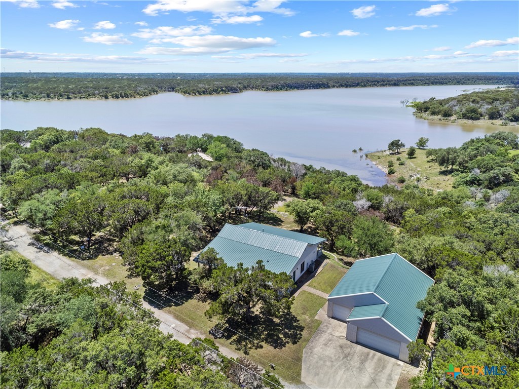READY TO START YOUR NEXT CHAPTER WITH BEAUTIFUL, LAKEVIEW, TEXAS SUNSETS ON OVER 1.332 ACRES? THIS IS A VERY SPECIAL MUST-SEE PROPERTY OVERLOOKING BELTON LAKE.  
This unique, semi-secluded property that lies a half mile down a private road features an 1850 square foot primary residence with two bedrooms, two bathrooms, a 1680 square foot detached Workshop/3-car garage and 450square foot mirrored front and back porches under a heavy-duty metal roof. The impressive westerly view of Belton Lake and the remainder of the wooded property cannot be overstressed! 
The immaculately maintained primary residence boasts a new HVAC system in May 2024 and features beautiful hardwood flooring, a large living room, and primary suite. Double doors open into a primary bath that features dual vanities, a make-up area, shower, and A HUGE primary closet.  Bedroom 2 with hardwood flooring is being used as an arts & crafts room/home office.
The massive workshop/garage/guest suite was originally designed to include a one bedroom, one bathroom efficiency apartment. A steel framed building with work benches, multiple high voltage outlets, and loads of workspace, it has unlimited possibilities! Priced right to sell quickly, it is a must-see property!