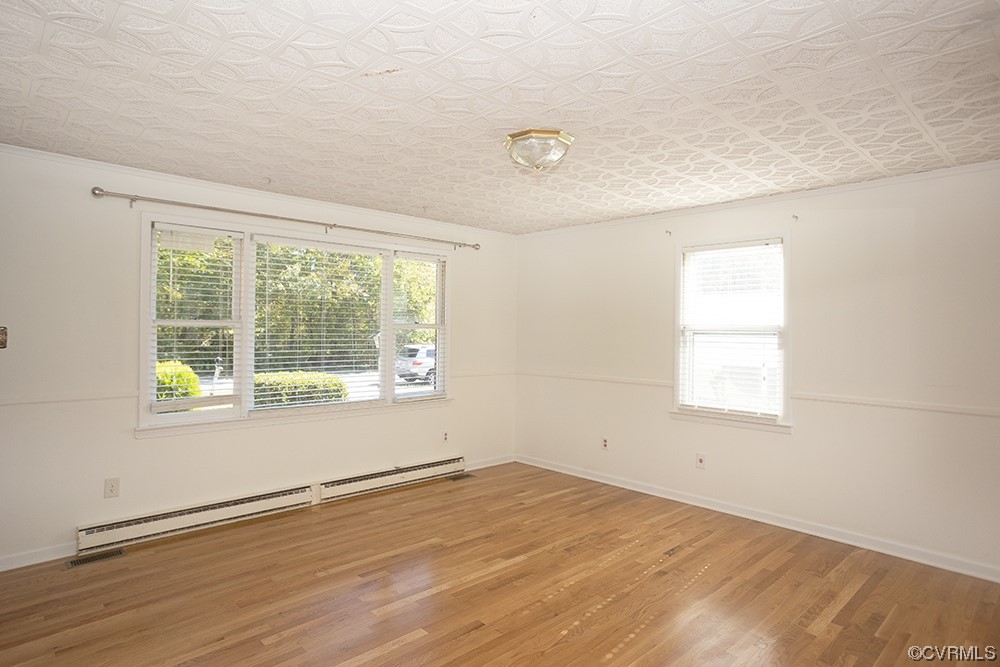 Unfurnished room with light hardwood / wood-style flooring and a baseboard radiator