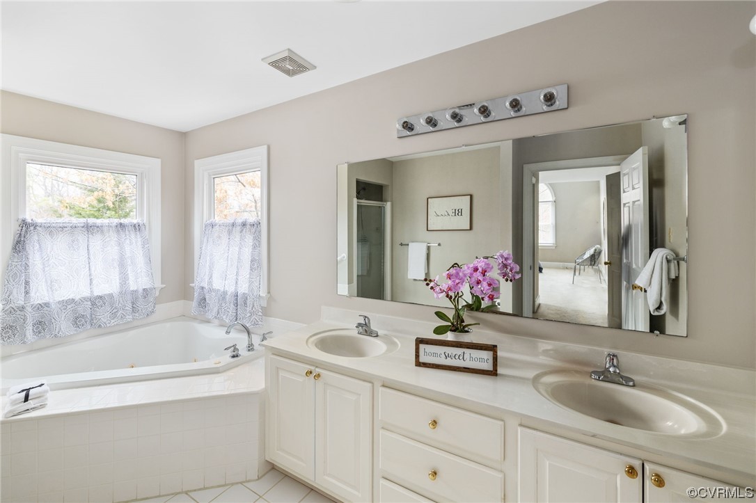 The Primary Bath with a 2 sink vanity, jetted tub and separate shower