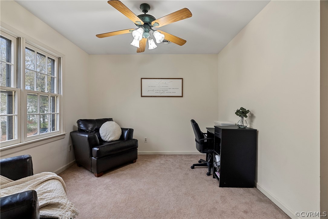 Home office with light carpet and ceiling fan