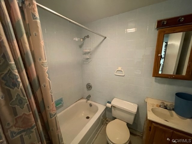Full bathroom featuring vanity, mirror, shower / bathtub combination with curtain, and tile walls