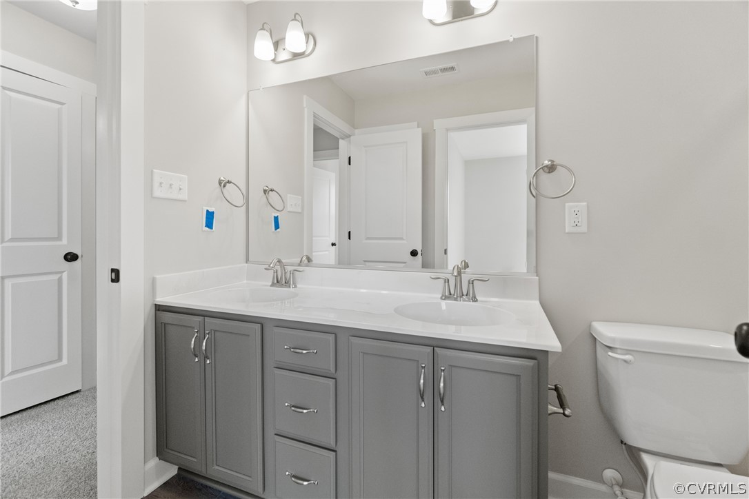 Bathroom featuring double vanity and toilet