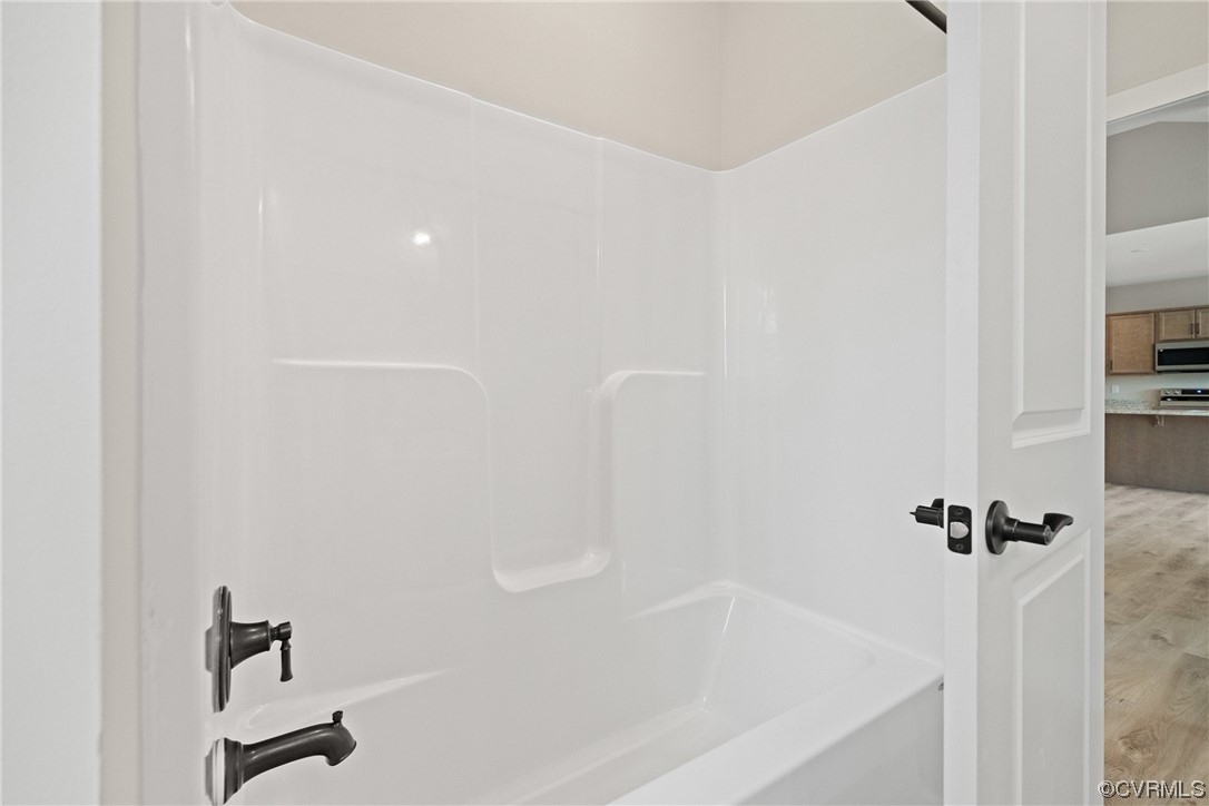 Bathroom featuring shower / bath combination and hardwood / wood-style flooring