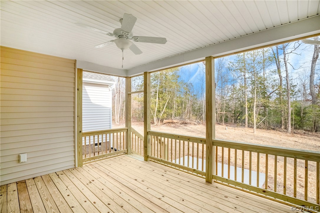 Unfurnished sunroom featuring a healthy amount of sunlight and ceiling fan