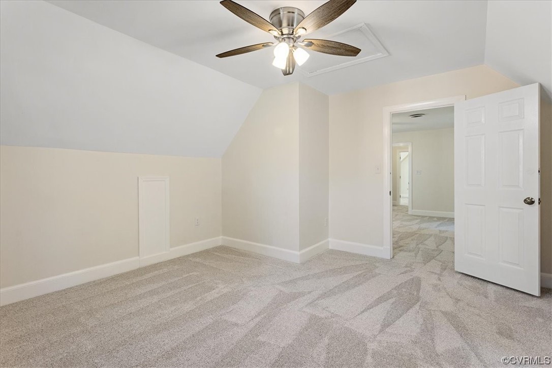 Bonus room with lofted ceiling, light carpet, and ceiling fan