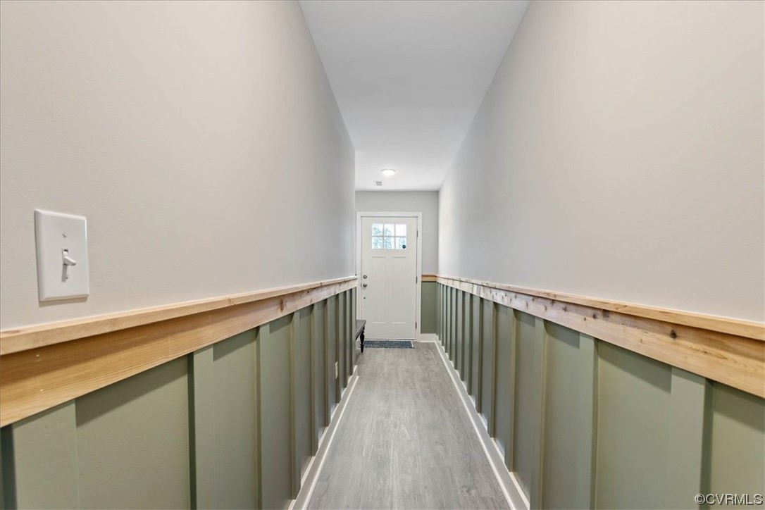 The bright foyer boasts custom board and batten wainscoting