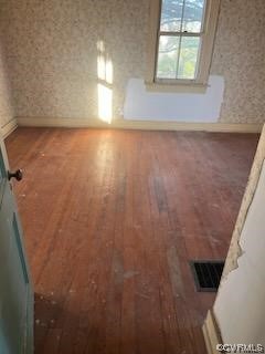 Empty room with hardwood / wood-style flooring