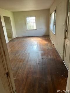 Empty room featuring dark hardwood / wood-style flooring