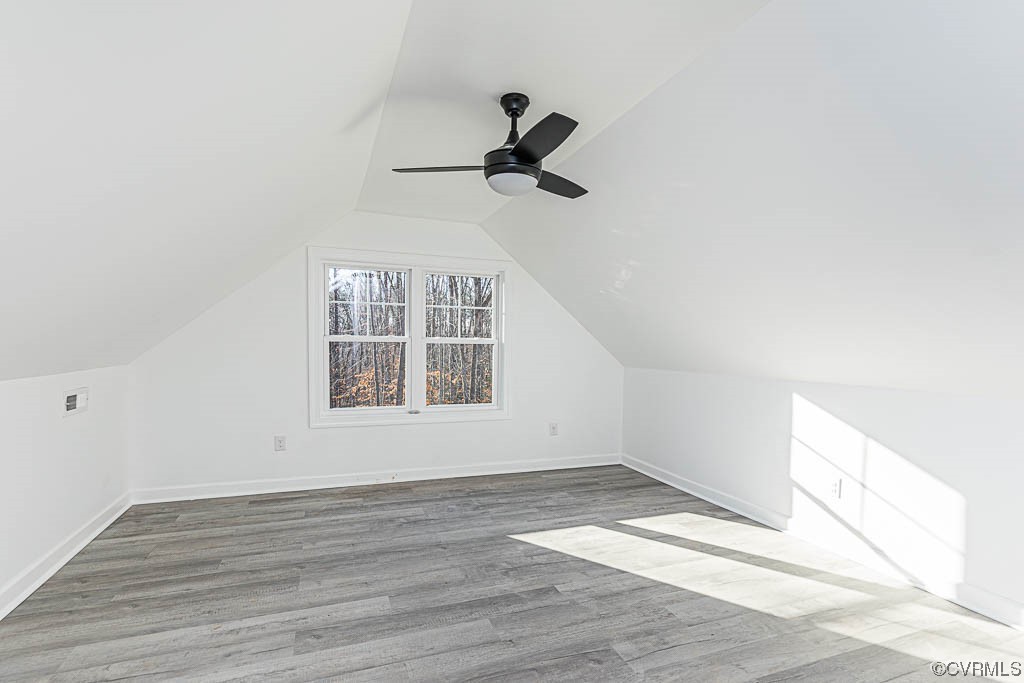 Bonus room featuring light wood-type flooring, lofted ceiling, and ceiling fan