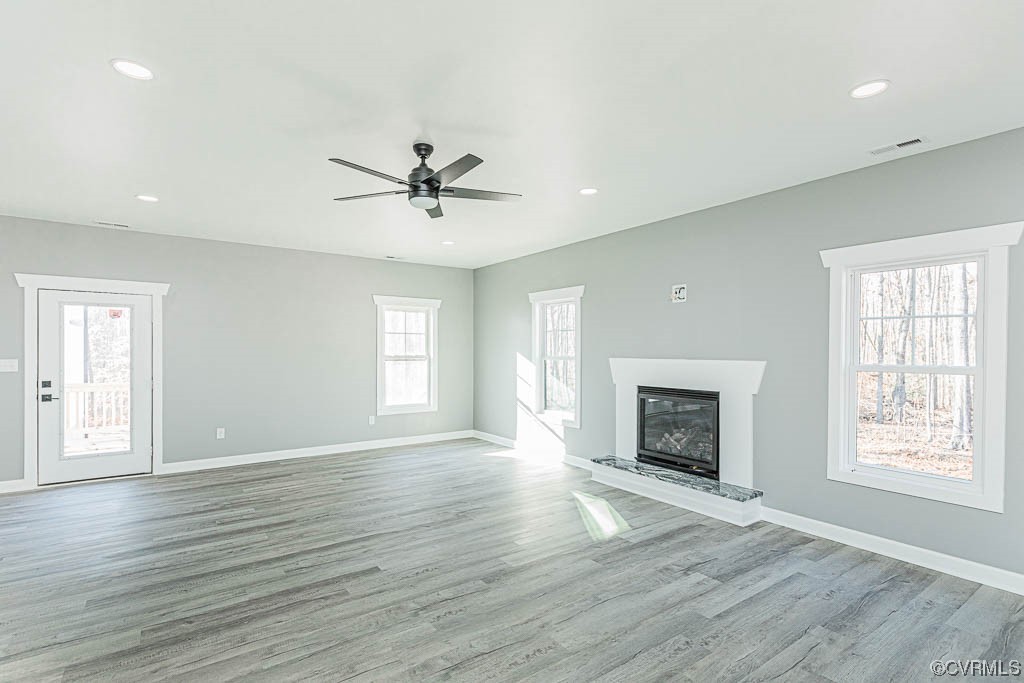 Unfurnished living room featuring light wood-type flooring and ceiling fan