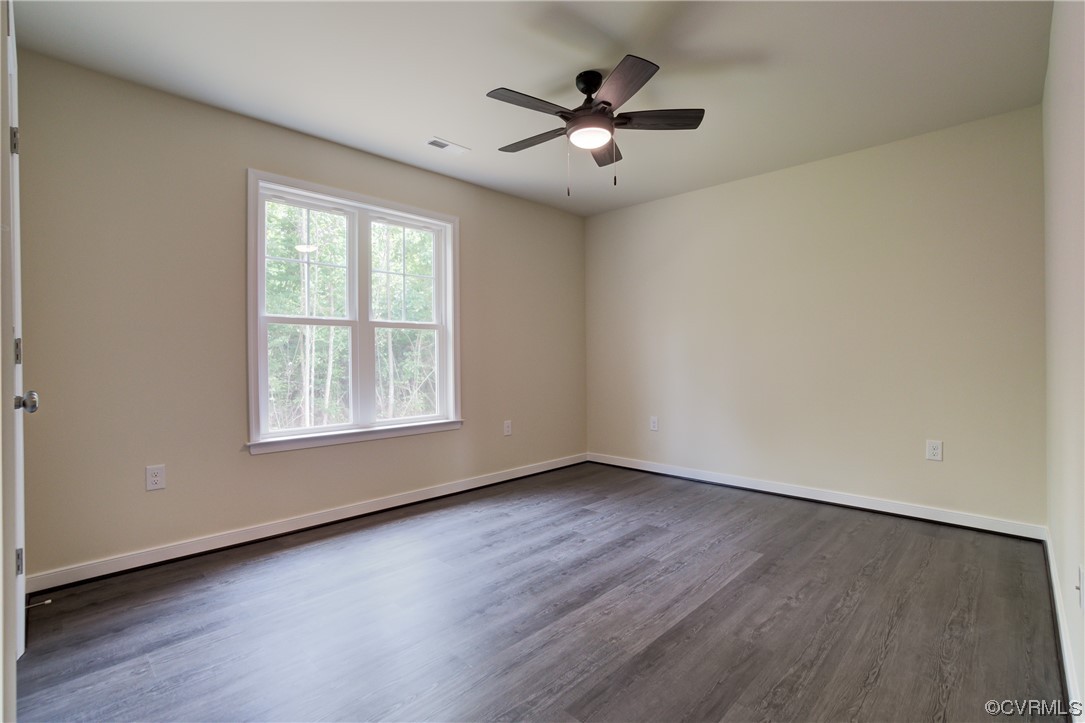 Unfurnished room with ceiling fan and dark hardwood / wood-style flooring