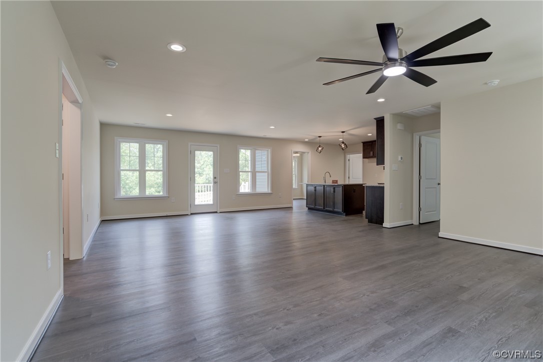 Unfurnished living room with dark wood-type flooring and ceiling fan
