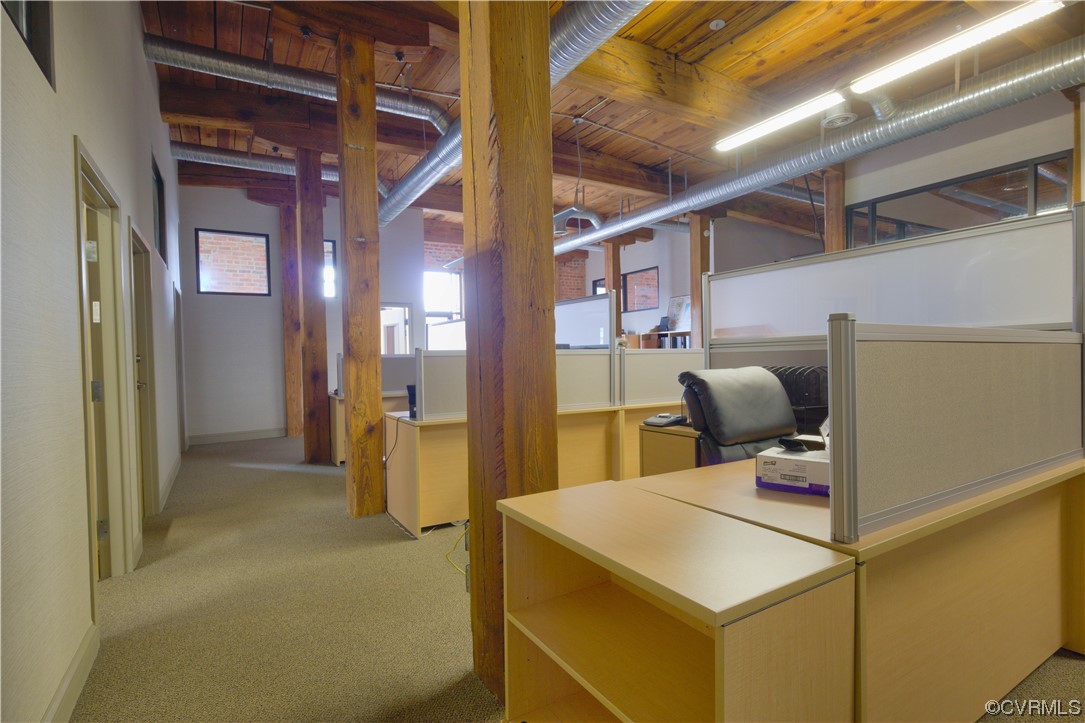 Carpeted office featuring wooden ceiling