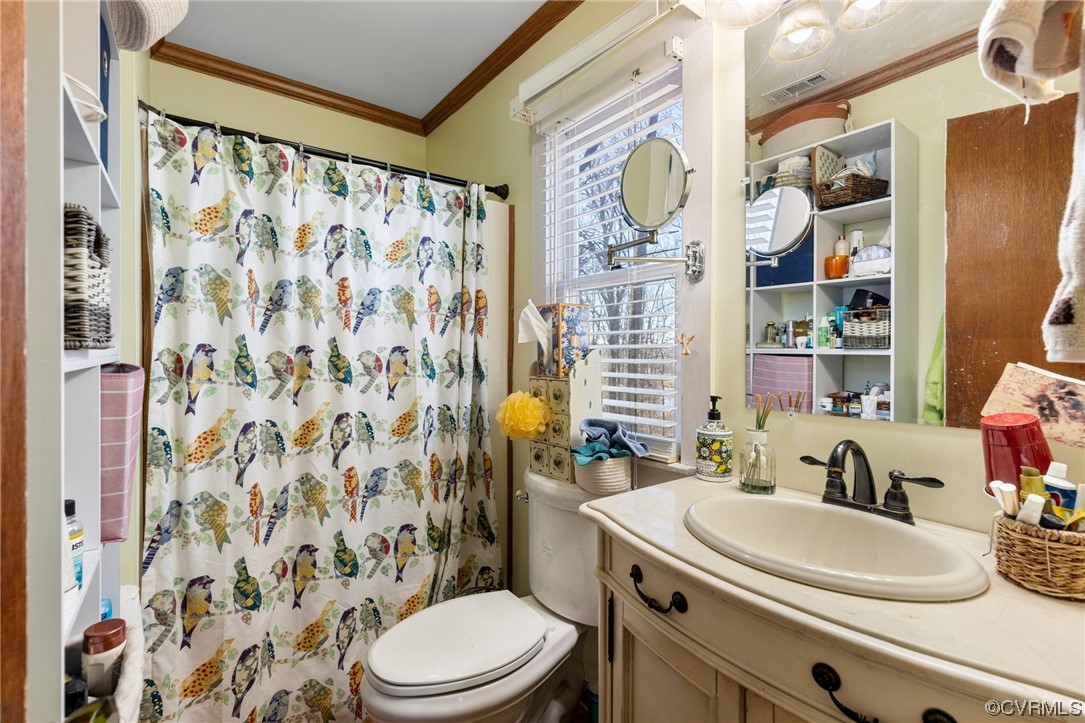 Bathroom with vanity, ornamental molding, and toilet
