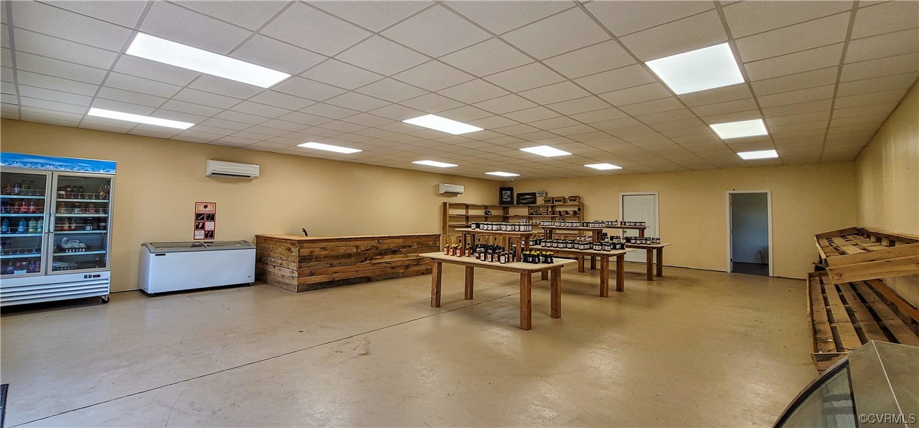 Game room with an AC wall unit and a paneled ceiling