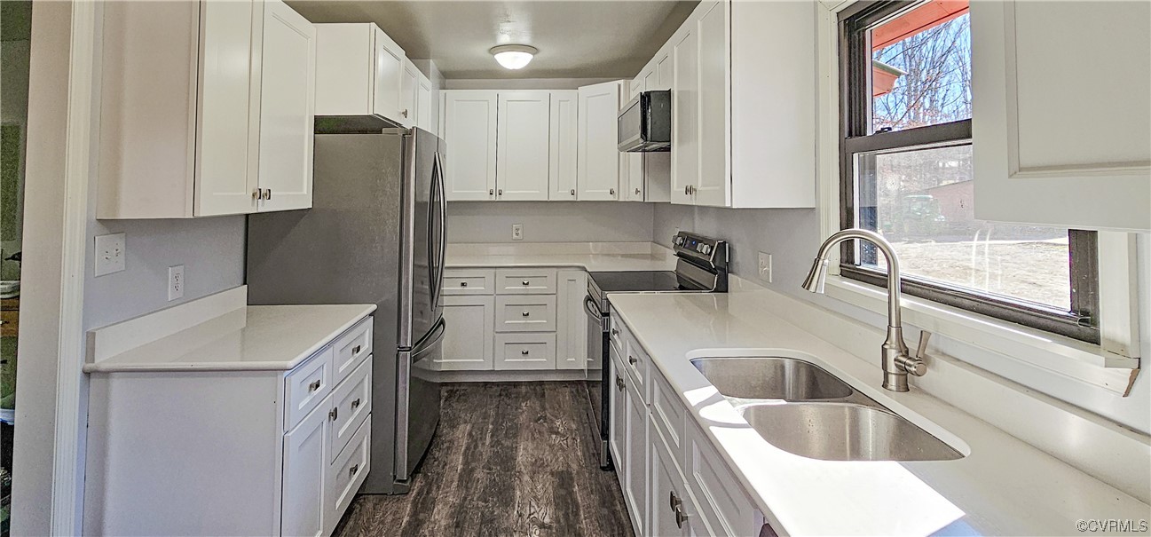 Kitchen featuring range with electric stovetop, sink, dark hardwood / wood-style floors, and white cabinets