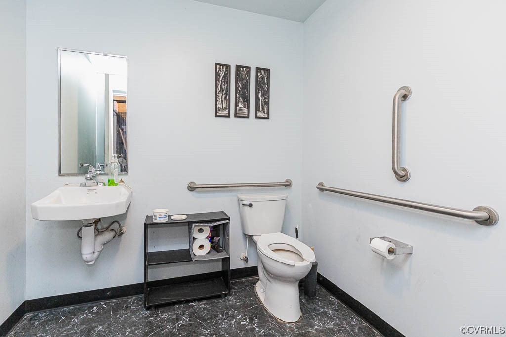 Bathroom with toilet, sink, and tile floors