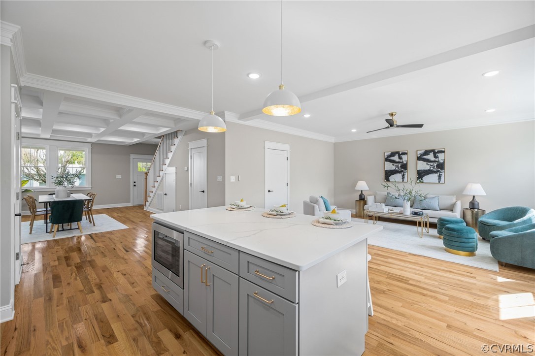 Kitchen featuring hanging light fixtures, light hardwood / wood-style flooring, coffered ceiling, and beamed ceiling
