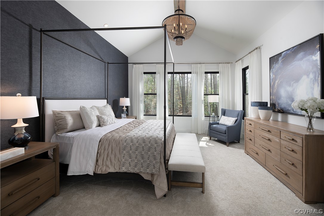 Carpeted bedroom with vaulted ceiling and an inviting chandelier