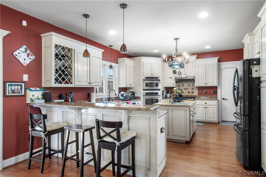 The kitchen is a showcase of modern design, with sleek lines and ample natural light pouring in from large windows or skylights overhead. From above, the high ceilings create a sense of grandeur, making the space feel even more expansive and inviting.