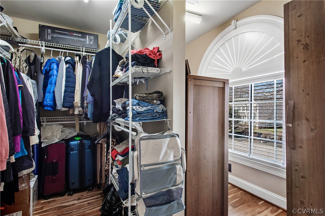 Primary oversized closet is spacious and well-appointed, offering plenty of room for storage, dressing, and grooming activities. Its layout is carefully planned to maximize functionality and efficiency while incorporating a dedicated dressing area and allowing natural light to illuminate the space.