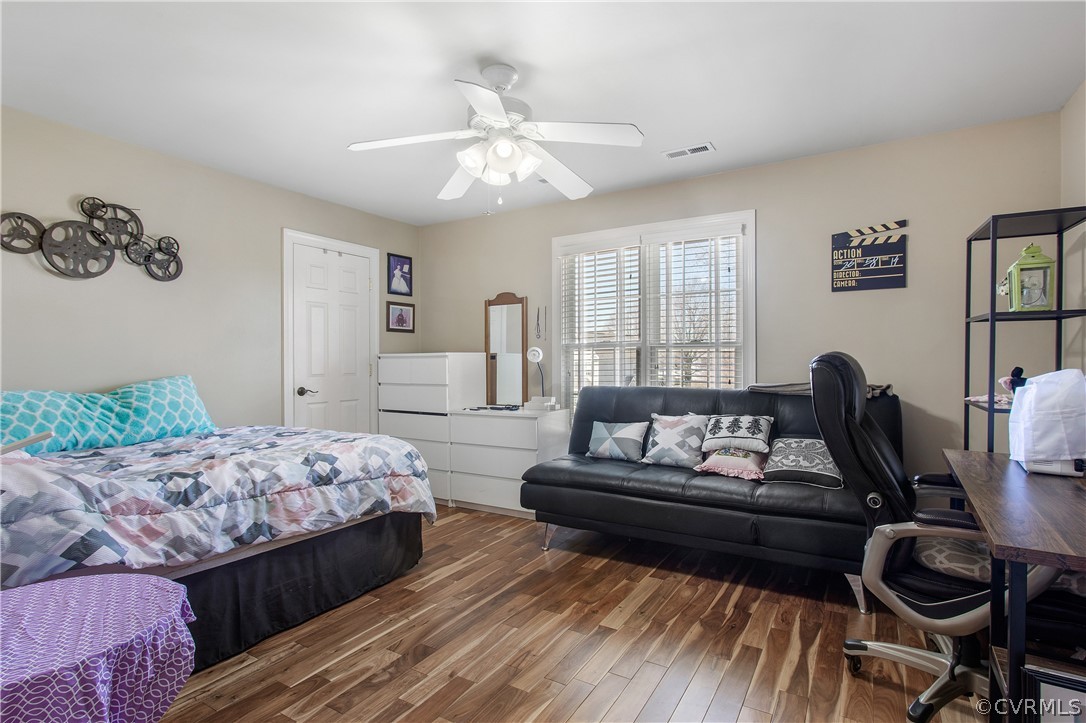 Bedroom featuring dark hardwood / wood-style flooring, ceiling fan, and a closet