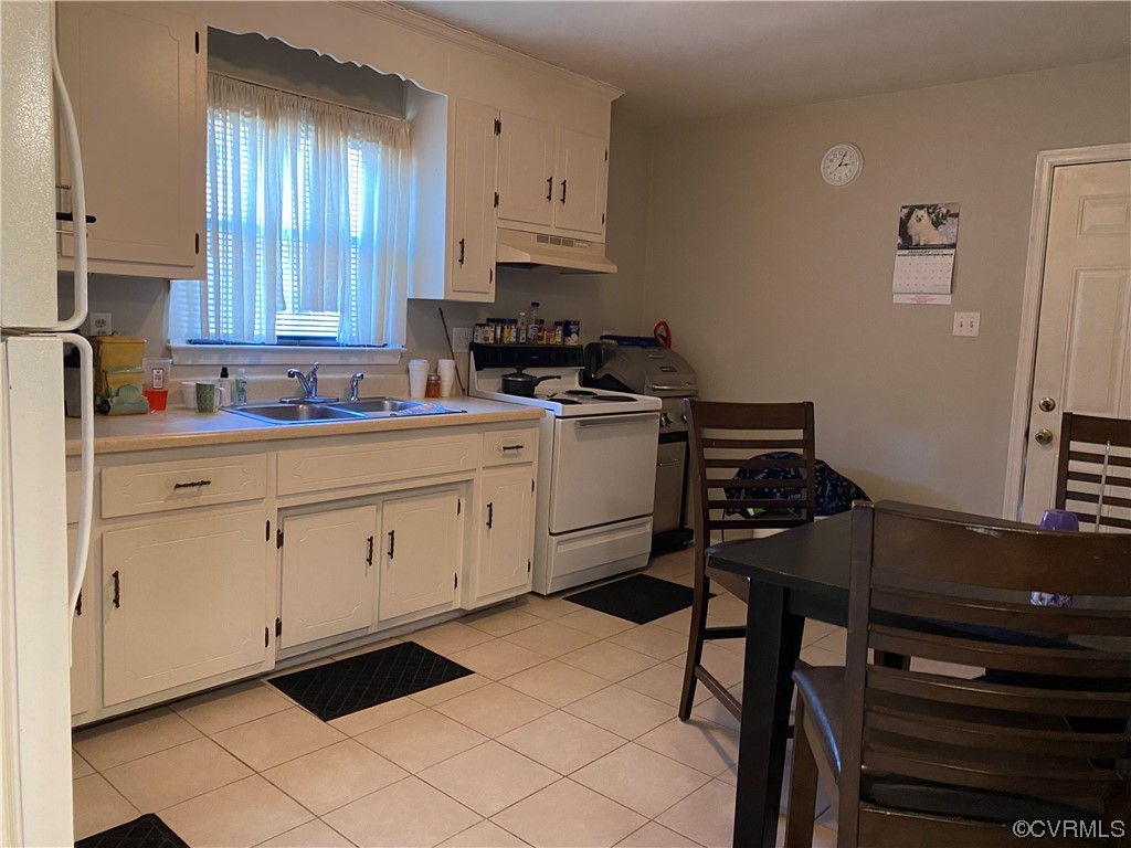 Kitchen of 1307: White cabinets, ceramic tile flooring, plenty of dining space.