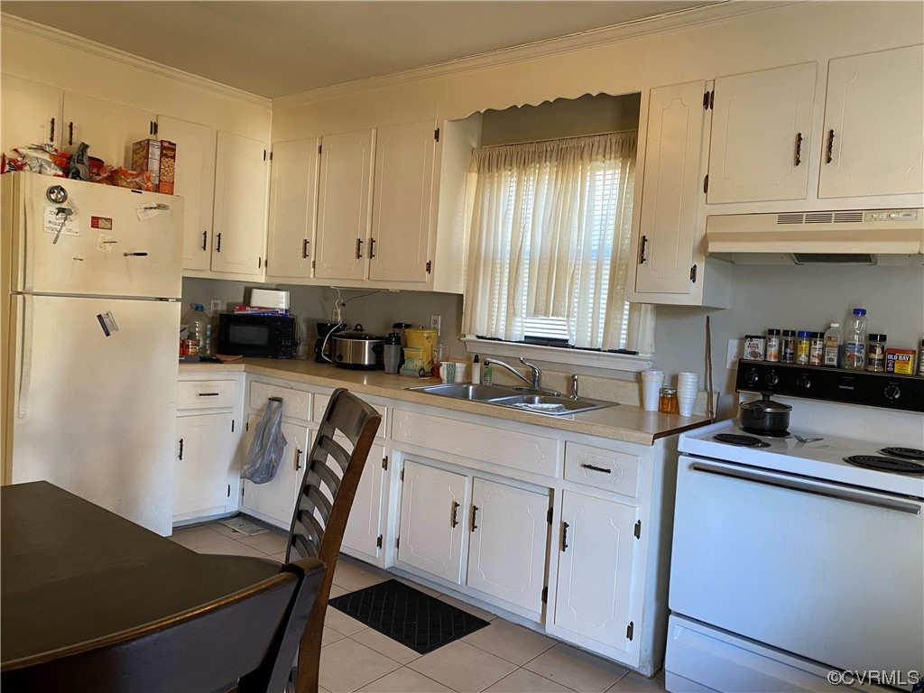 Kitchen of 1307: White cabinets, ceramic tile flooring, plenty of dining space.