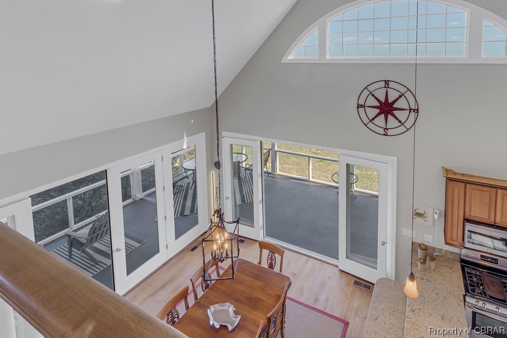 Living room featuring light hardwood / wood-style flooring and high vaulted ceiling