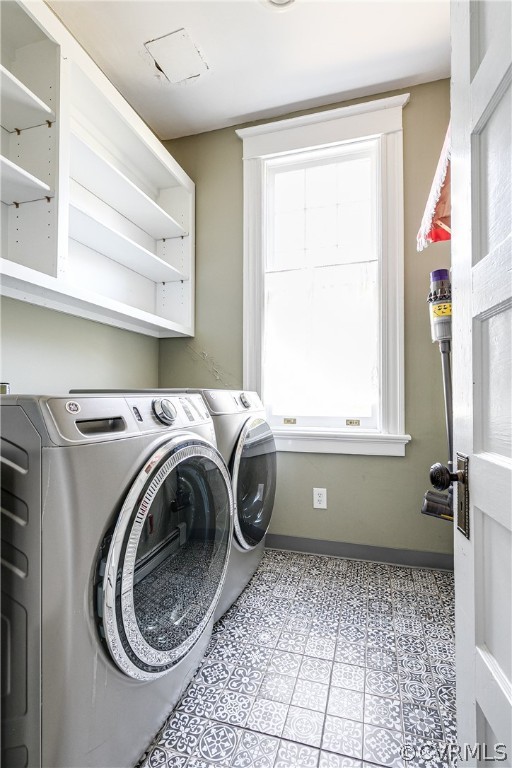 First floor Laundry room featuring washing machine and dryer, a healthy amount of sunlight, and light tile flooring