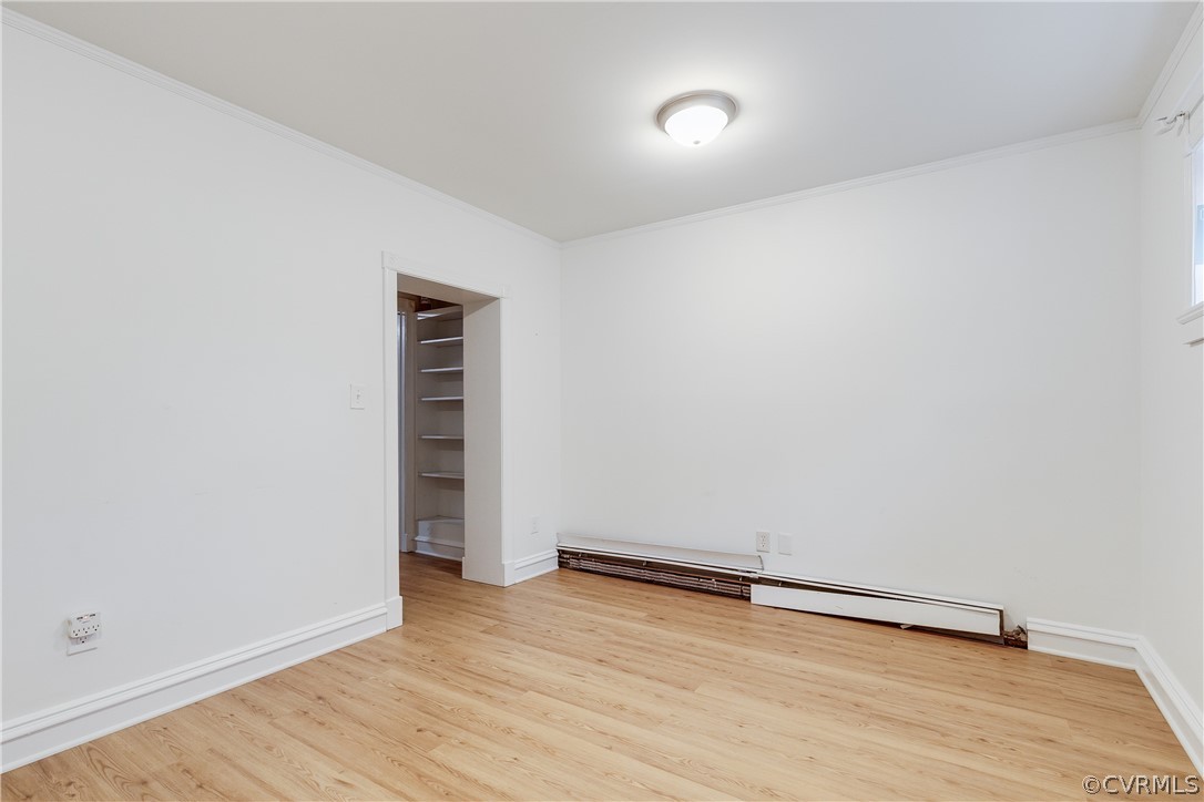 Studio Apt Bedroom and a baseboard radiator, ornamental molding, and light wood-type flooring