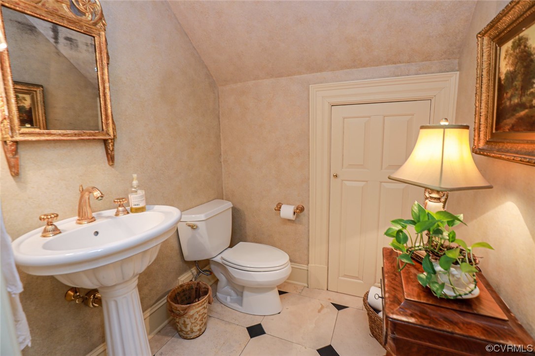 Powder Room under Staircase with Pedestal Sink and Large Closet.