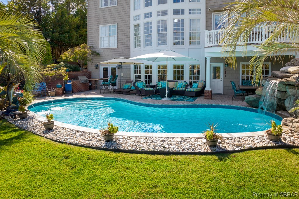 View of swimming pool with a yard, an outdoor hangout area, pool water feature, and a patio