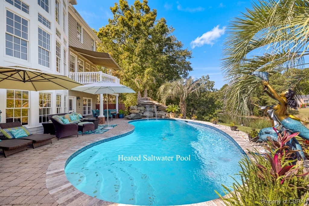 View of pool with an outdoor hangout area, a patio, and pool water feature