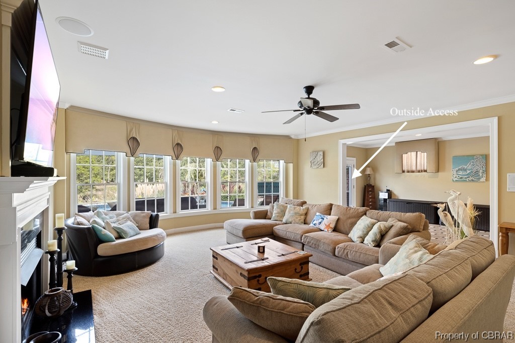 Living room with crown molding and ceiling fan