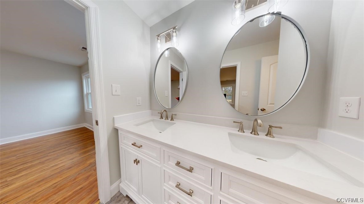 Bathroom with dual bowl vanity, hardwood / wood-style floors, and tiled shower / bath