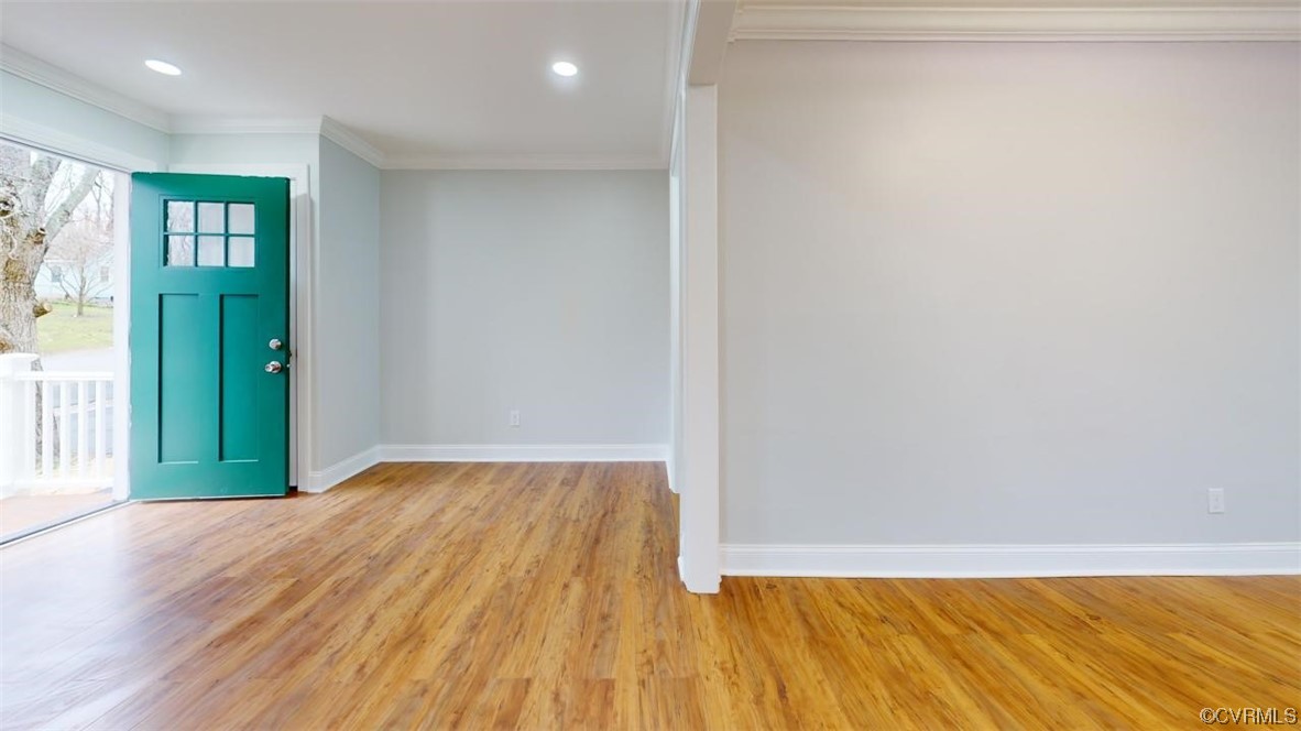 Entryway with crown molding, light hardwood / wood-style floors, and a healthy amount of sunlight
