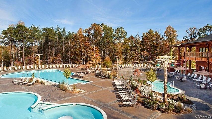 View of swimming pool with a hot tub and a patio area